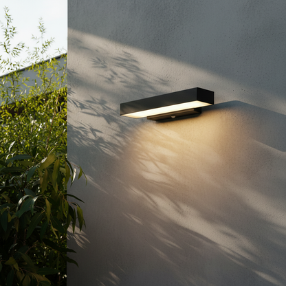 modern black aluminum outdoor wall lamp illuminating a contemporary patio entrance at dusk
