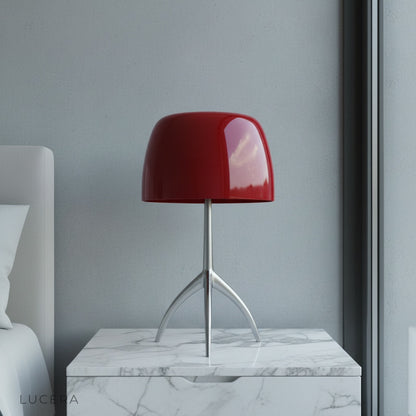 Albescent Table Lamp glowing warmly on a mid-century modern bedside table in a cozy bedroom