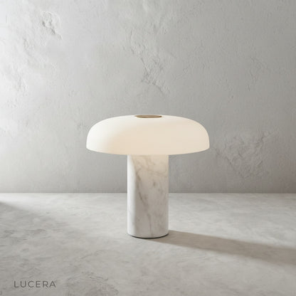 Beatrice table lamp with marble base and dome shade on a console in a bright living room