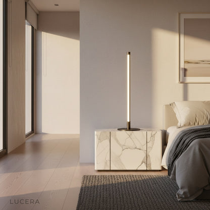 Pascal Table Lamp glowing warmly on a bedside table in a modern minimalist bedroom