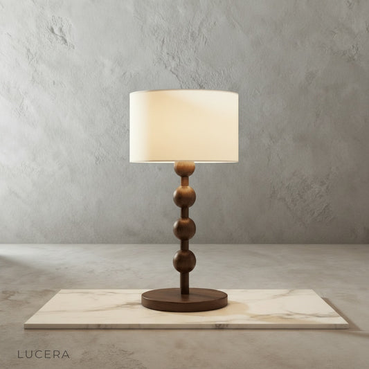 Boreal Table Lamp stacked wood spheres glowing on rustic wooden bedside table in cozy bedroom