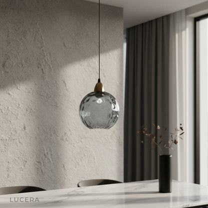 Kronos pendant light glowing above modern dining table in bright living room