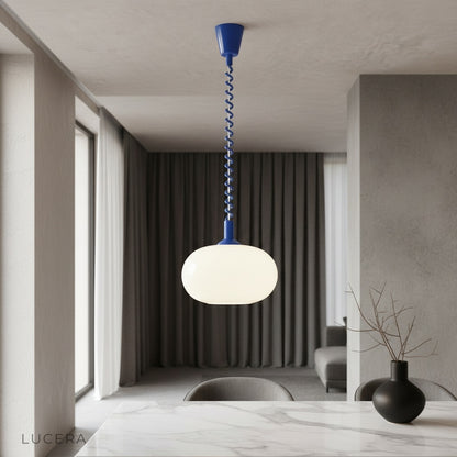 Xanthous pendant light glowing over modern kitchen counter with opal glass shade
