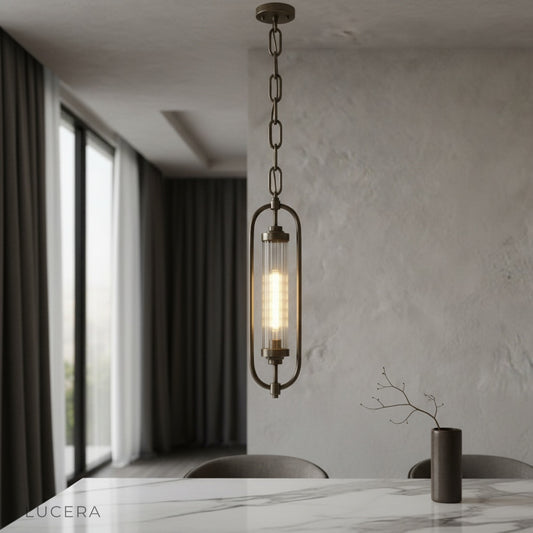 Zigzag Lucis brass pendant lamp glowing over modern dining table with ribbed glass diffuser