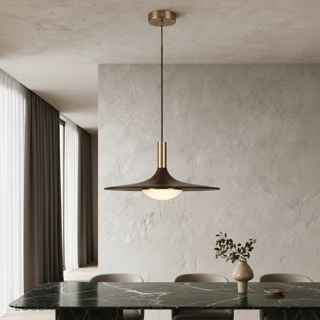 Juju pendant light glowing warmly above a modern dining table in an elegant interior
