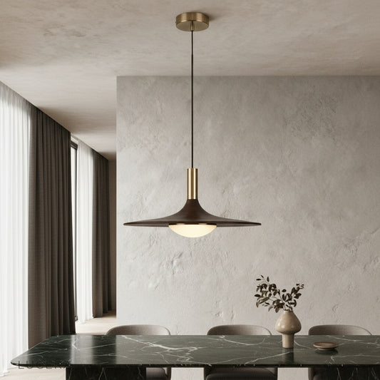 Juju pendant light glowing warmly above a modern dining table in an elegant interior