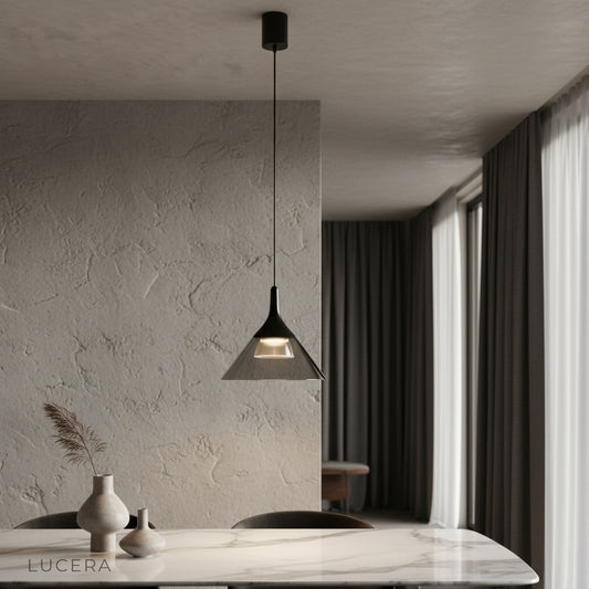 Calypso Pendant Light hanging over modern dining table with clear glass shade