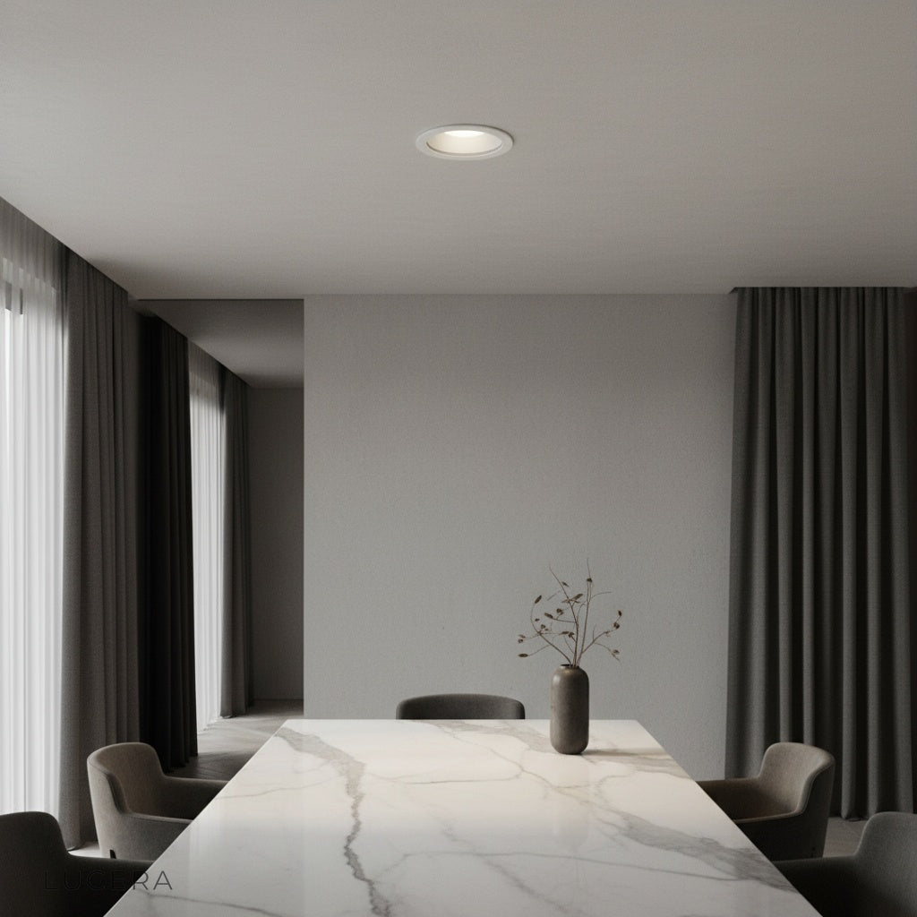 Brevity adjustable downlight illuminating a modern living room with sloped ceiling