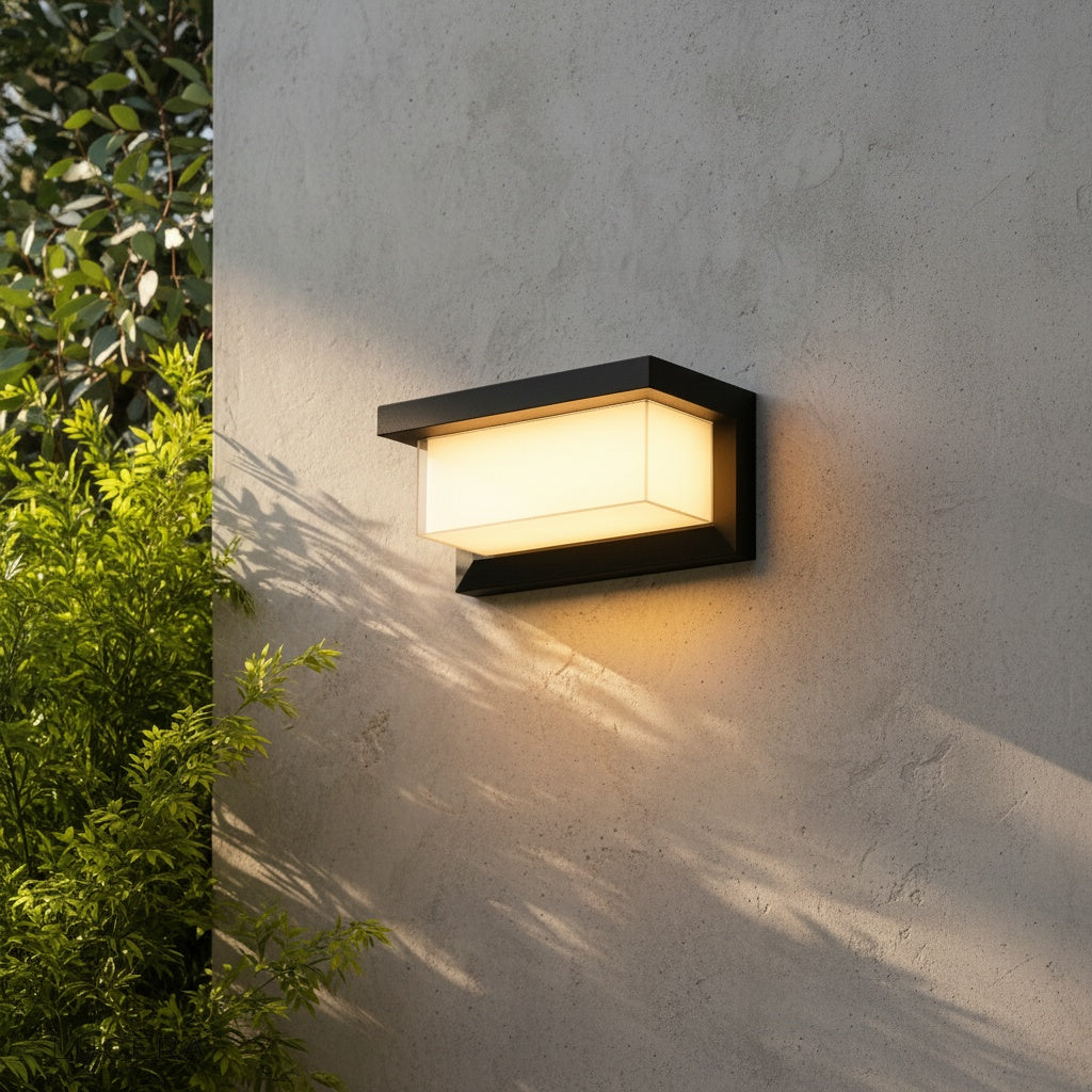 Leonora outdoor wall lamp glowing warmly beside a modern entryway at dusk