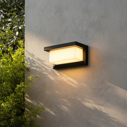 Leonora outdoor wall lamp glowing warmly beside a modern entryway at dusk