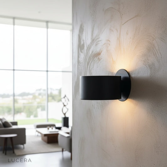 Hector Wall Lamp brushed brass glowing above a modern bedroom nightstand