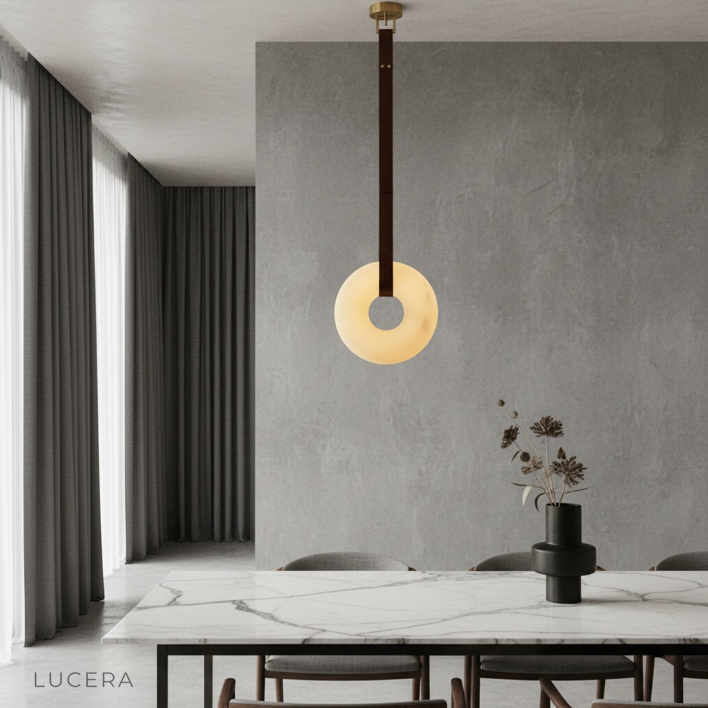 Butte Alabaster pendant light glowing above modern dining table in elegant living room