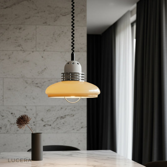 Cima pendant light glowing over mid-century dining table in cozy living room