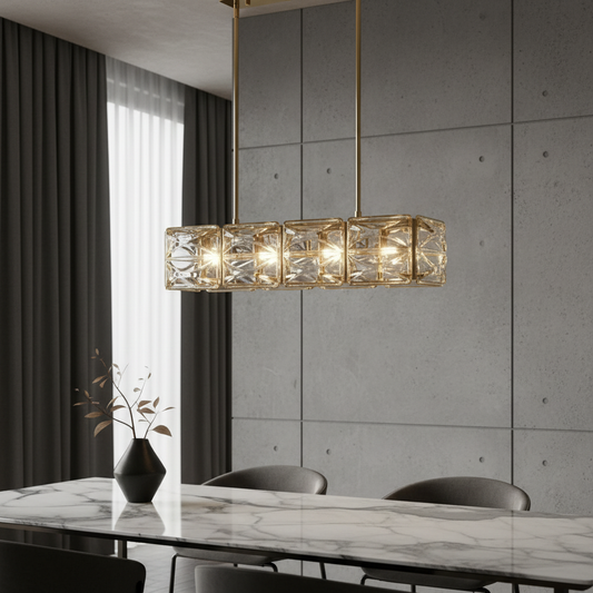 Karst Linear Chandelier with warm gold finish illuminating a modern dining room with wooden table and textured glass shades