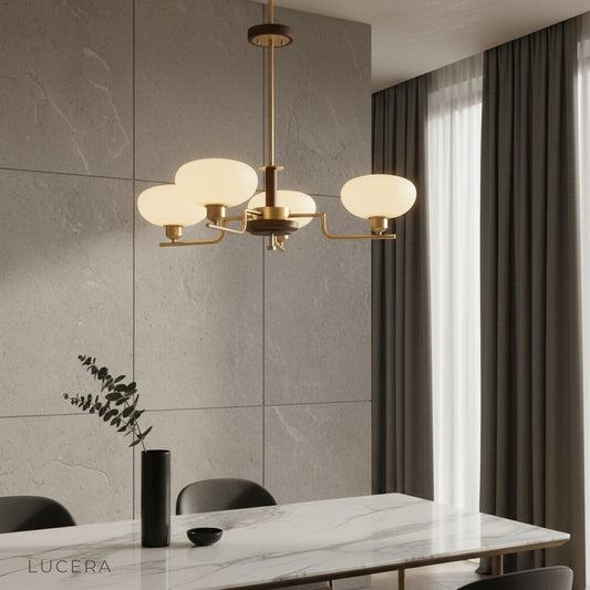 Eronix brass inlet chandelier illuminating a modern dining room with wooden table and glass shades