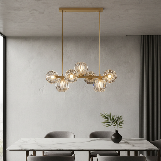 Unisono Linear Chandelier glowing warm white over modern dining table in open living room