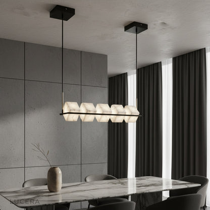 Locket Alabaster Chandelier glowing over modern dining table with black linear frame