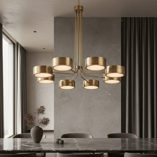 Lacrima brass chandelier glowing over a dining table with warm ambient light