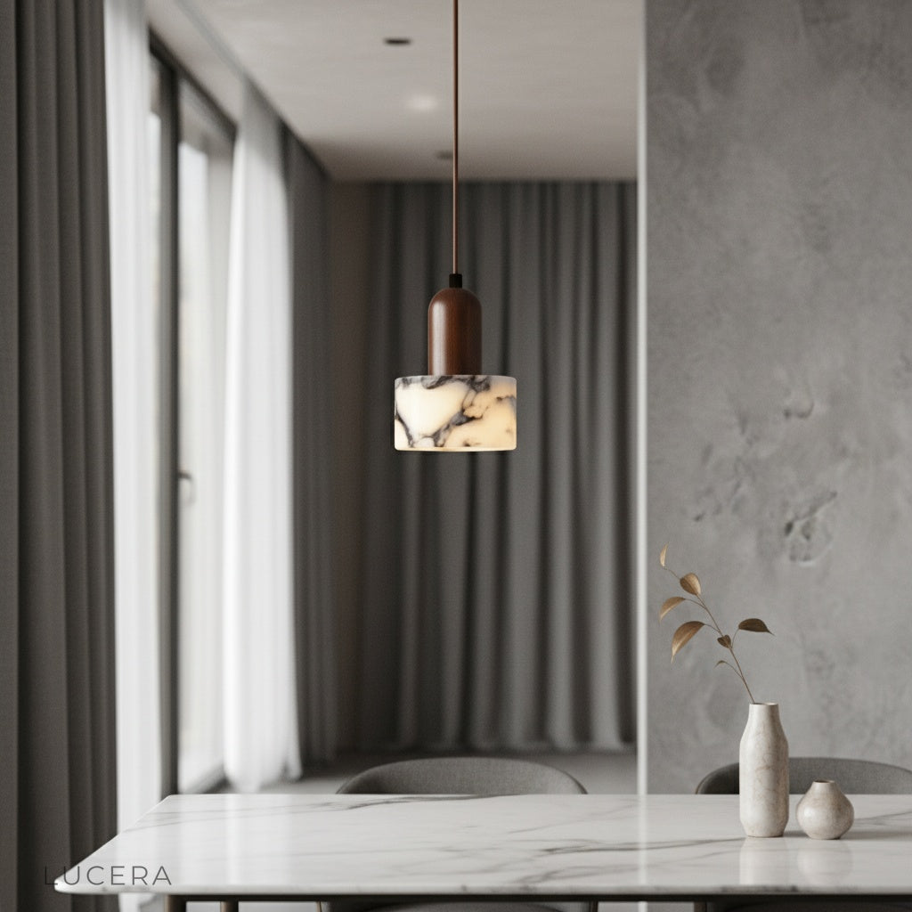 Aglow pendant light by Lucera casting warm diffused glow over modern dining table with wooden chairs