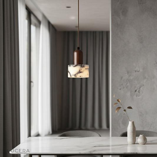 Aglow pendant light by Lucera casting warm diffused glow over modern dining table with wooden chairs