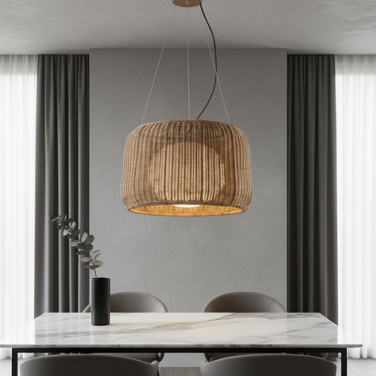 Zealous pendant light hanging over a dining table with woven rattan shade casting warm glow