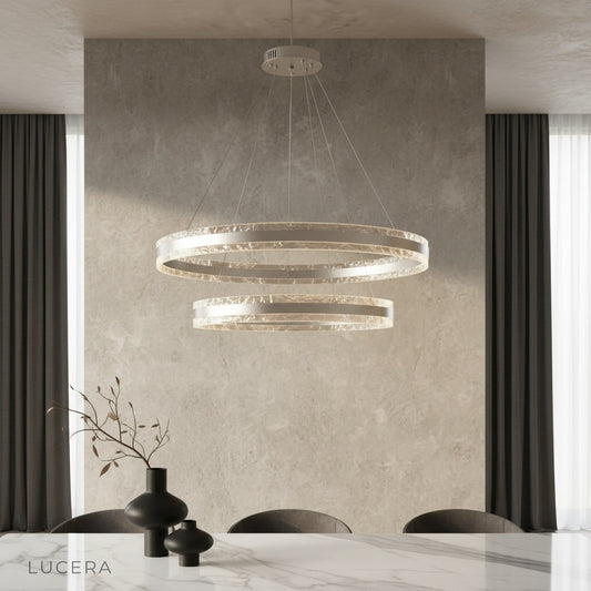 Bacchus Round Chandelier glowing warmly over a modern dining table in an elegant living room