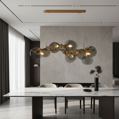 Calmo gold glass rectangle chandelier glowing over modern dining table with white panels