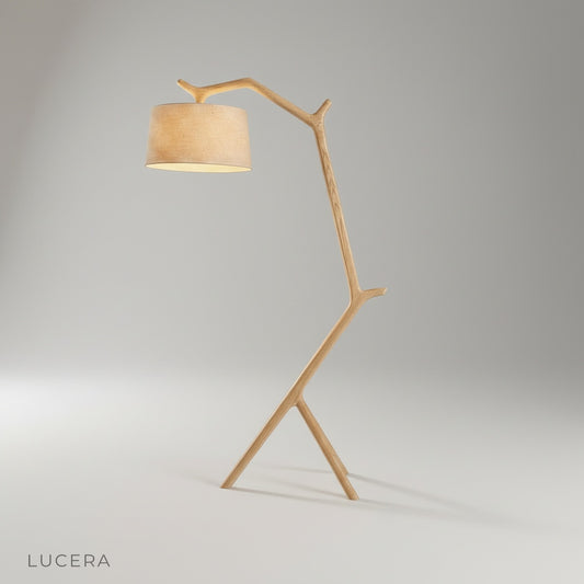 Studio shot of cantilever floor lamp with warm wood stem and beige fabric shade on clean background