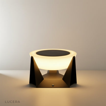 modern minimalist Wilhelmina solar garden lamp glowing warmly on a patio table at dusk
