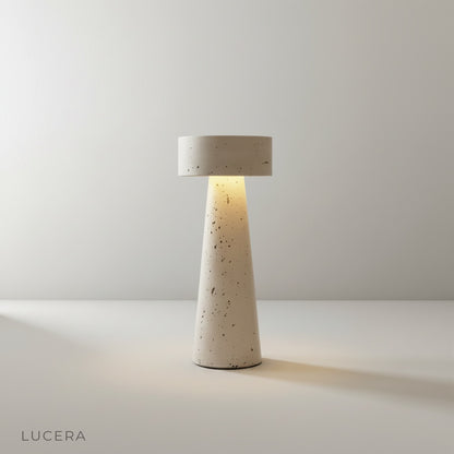 Natural yellow travertine table lamp with tapered conical base on clean white studio background