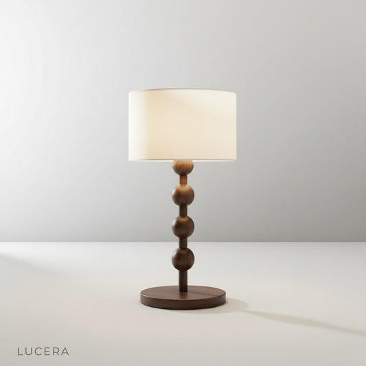 studio shot of Boreal Table Lamp with stacked solid wood base and neutral fabric shade on white background