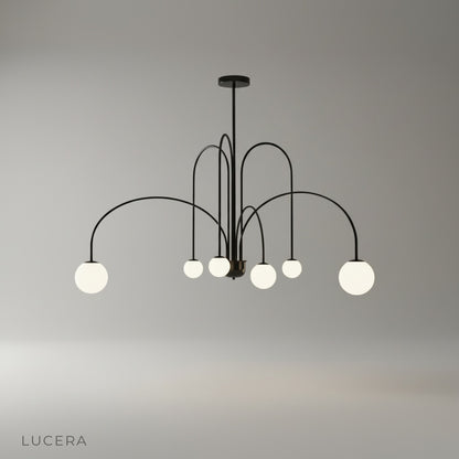 Studio shot of Unico Chandelier with arched iron frame and opal glass globes