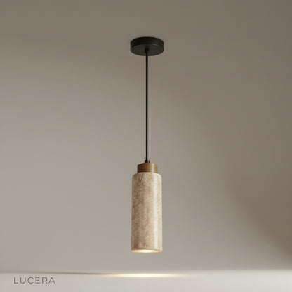 Studio shot of Clandestine pendant light with natural travertine dome shade on sleek black cable against white background