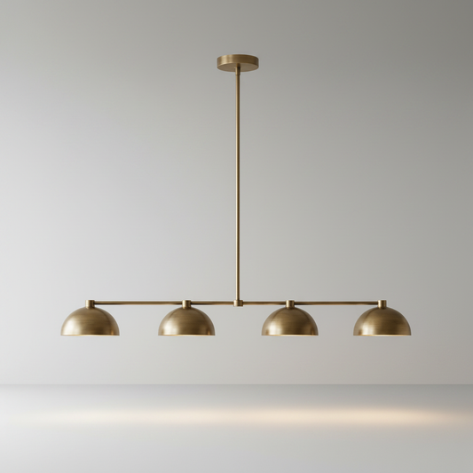 Studio shot of Ursule linear brass pendant light with four dome shades on clean neutral background