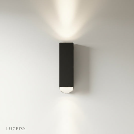Studio shot of cylindrical aluminum wall lamp with acrylic shade front view