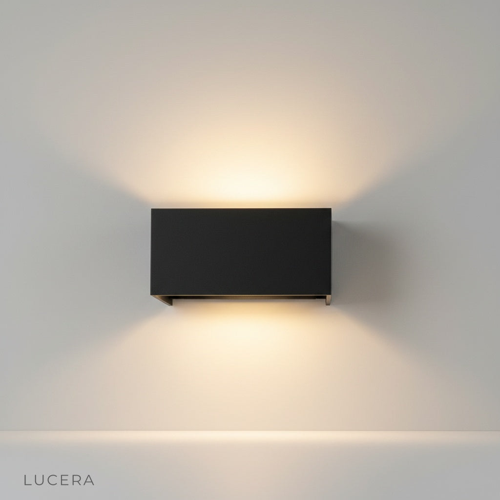 modern black dowel outdoor wall lamp illuminating brick patio wall at dusk