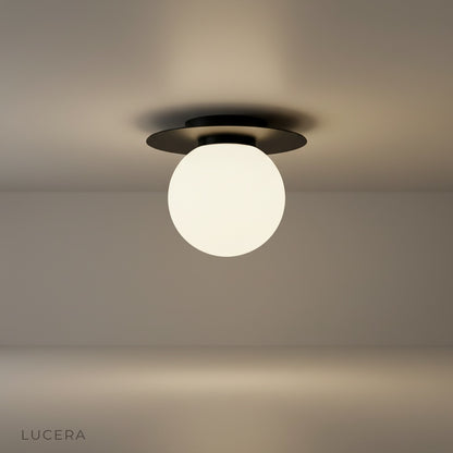 studio shot of gold-plated Bijou ceiling light with clear glass ball on white background