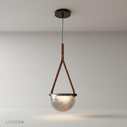 studio shot of Glimmer pendant light with transparent glass shade and metal base