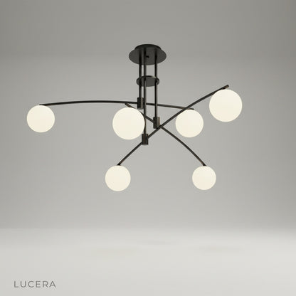 studio shot of Yonder ceiling lamp front view showing sculptural black iron frame and three frosted glass globes