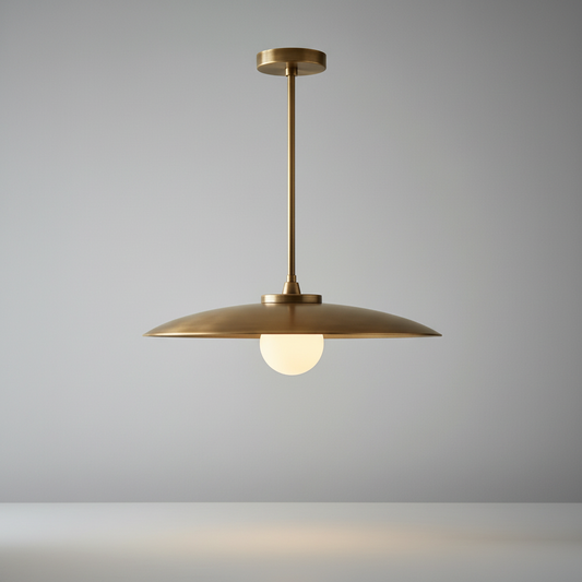 Studio shot of Sylvaine pendant light with wide brass shade and vertical stem