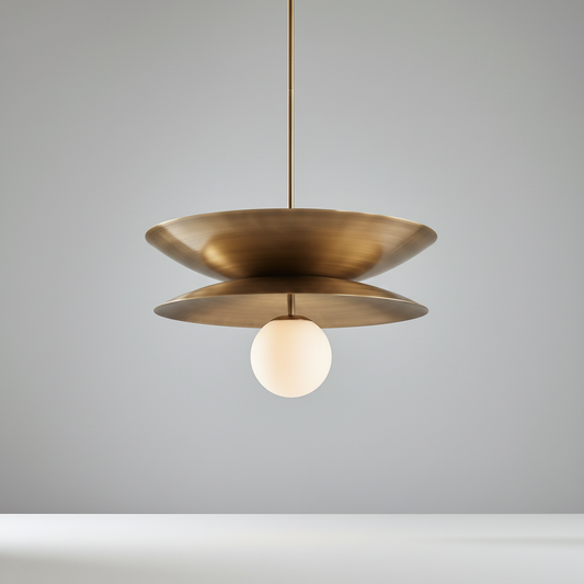 studio shot of Tremulous pendant light front view with layered brass discs and glass orb