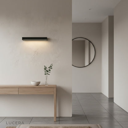 Goccia wall lamp in minimalist hallway, soft glow creating inviting atmosphere
