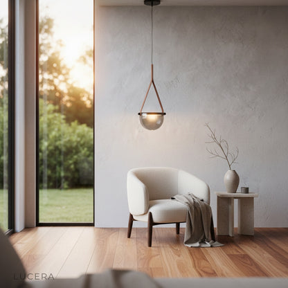 Glimmer pendant light with leather strap detail against a textured concrete wall