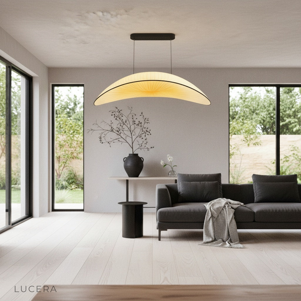 Dart Silk Chandelier glowing warmly at dusk above a cozy reading nook with armchair and bookshelf