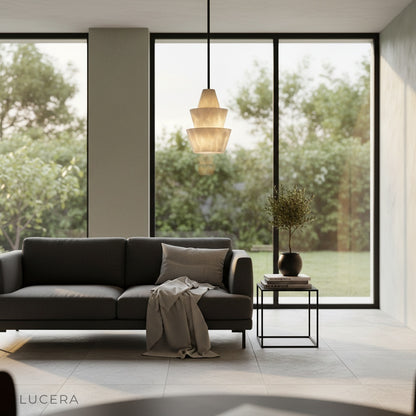 Sculptural Fillet Alabaster pendant light in contemporary hallway with concrete wall and plant