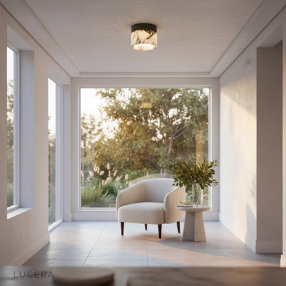 Nighttime lifestyle shot of Lucera Raphael marble ceiling light casting soft pool of light on floor