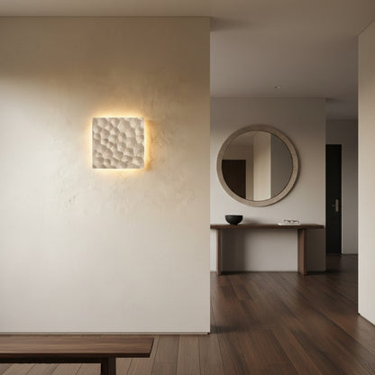 Wampum wall lamp mounted above minimalist bed in dark bedroom