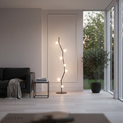 Sculptural floor lamp casting ambient glow in cozy reading corner at dusk