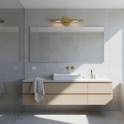 Keziah brass mirror light with rotatable arms illuminating a chic dressing table
