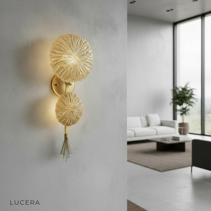 Sacro lamp glowing in hallway niche with gold finish casting patterned light on wall